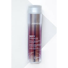 Load image into Gallery viewer, Joico Defy Damage Protective Shampoo is a rich shampoo that helps boost hair with a rich, luxurious lather featuring damage-preventing ingredients, this gentle daily cleanser swiftly sloughs away dirt, impurities, and buildup without roughing up the hair cuticle or stripping vibrant color. The result: shiny, smooth, clean strands—wonderfully resilient and healthy-looking