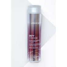 Load image into Gallery viewer, Joico Defy Damage Protective Shampoo is a rich shampoo that helps boost hair with a rich, luxurious lather featuring damage-preventing ingredients, this gentle daily cleanser swiftly sloughs away dirt, impurities, and buildup without roughing up the hair cuticle or stripping vibrant color. The result: shiny, smooth, clean strands—wonderfully resilient and healthy-looking
